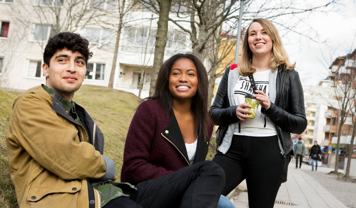 En grupp unga människor sitter på en bänk.