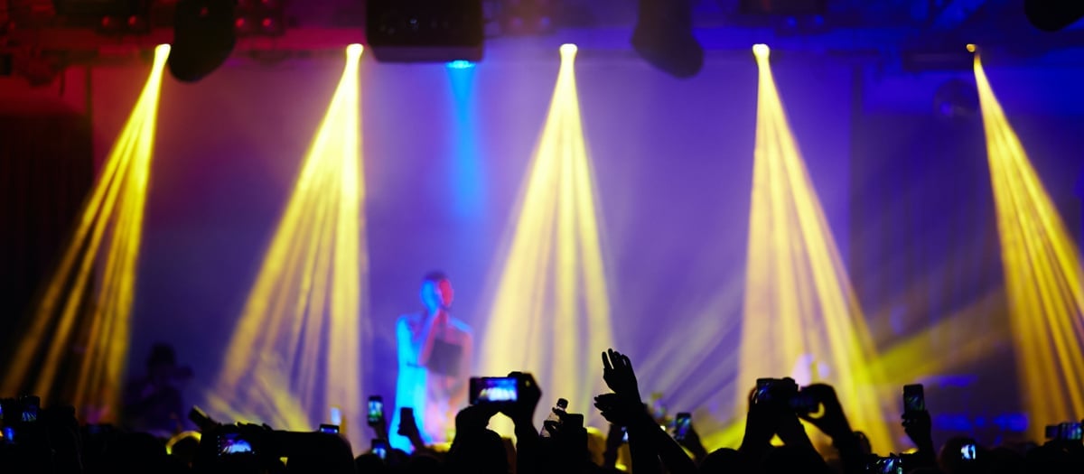 Scen med belysning och publik som tittar på konsert